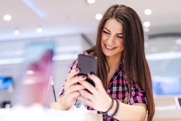 Gelukkig Brunette Staande Tech Winkel Uitproberen Van Slimme Telefoon Willen — Stockfoto