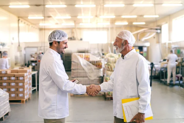 Двое Счастливых Коллег Пожимают Друг Другу Руки Стоя Пищевой Фабрике — стоковое фото