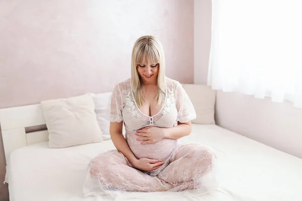 Happy Pregnant Blonde Caucasian Woman Sitting Bed Legs Cross Holding — Stok Foto