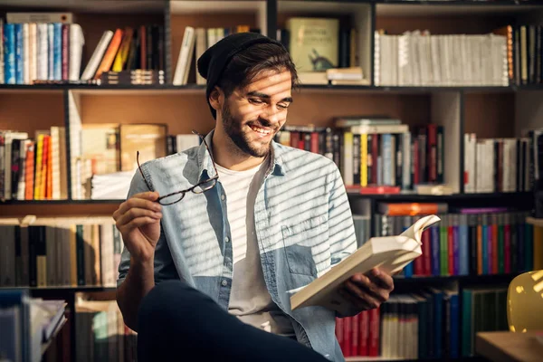 Lindo Niño Hipster Sonriente Sentado Suelo Una Biblioteca Mirando Través — Foto de Stock