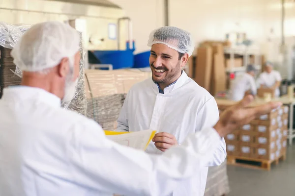 Dois Trabalhadores Caucasianos Terno Protetor Conversando Sorrindo Fábrica Alimentos — Fotografia de Stock