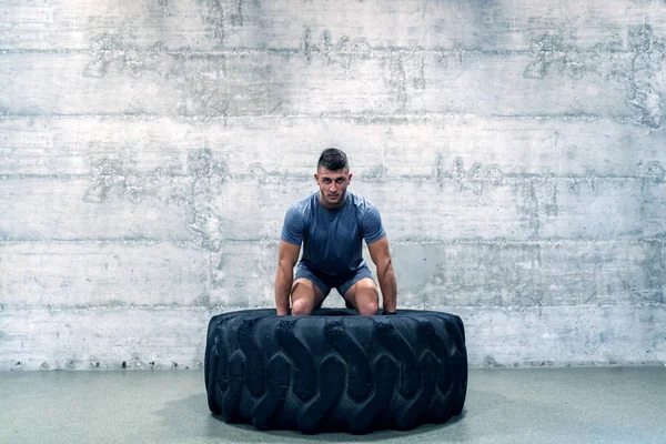 Bărbat Puternic Musculos Îmbrăcăminte Sport Ridicarea Anvelopei Timp Picioare Fața — Fotografie, imagine de stoc