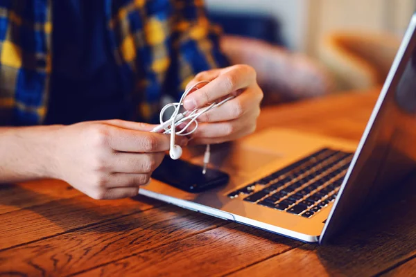 Gros Plan Homme Déroulant Ses Écouteurs Sur Bureau Ordinateur Portable — Photo