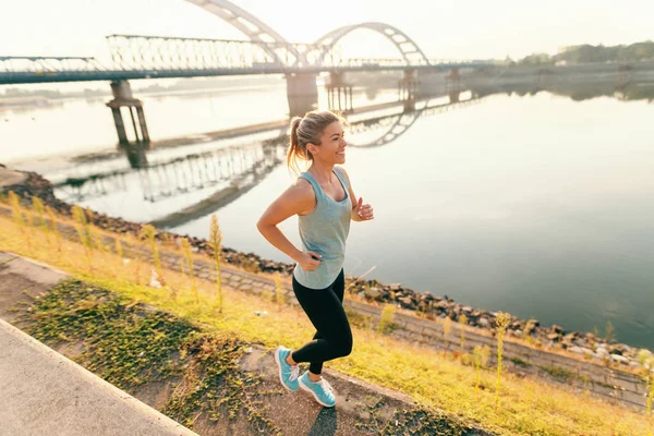 快乐的运动金发碧眼的女人在跑车跑在河边在早晨 — 图库照片