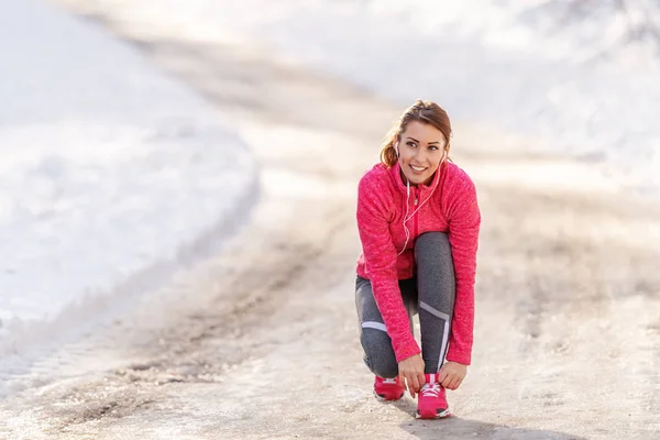 Donna Allacciatura Lacci Delle Scarpe Mentre Accovacciato Sul Sentiero Inverno — Foto Stock