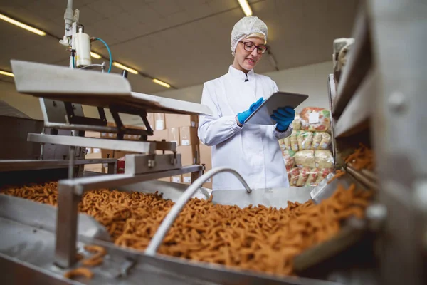 Pracownicy Przy Użyciu Tabletu Kontrolowania Produktów Stojąc Fabryce Żywności — Zdjęcie stockowe