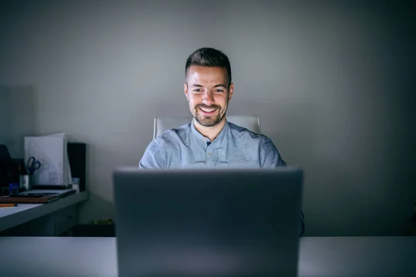 Usměvavý Pohledný Podnikatel Pracuje Projektu Pozdě Noci Zatímco Sedí Kanceláři — Stock fotografie