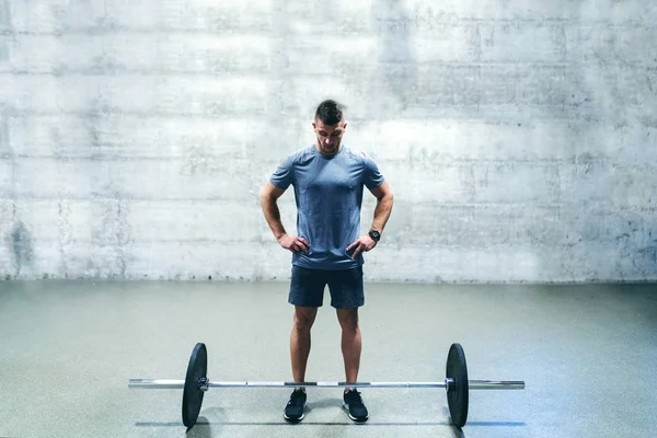 Caucasian Bodybuilder Looking Barbell While Standing Hands Hips Background Wall — Stock Photo, Image