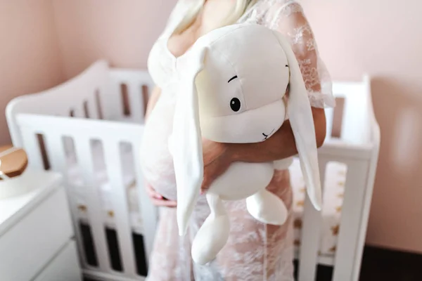 Hamile Kadının Tutmak Dururken Bunny Oyuncak Bebek Odasında Yakın Çekim — Stok fotoğraf
