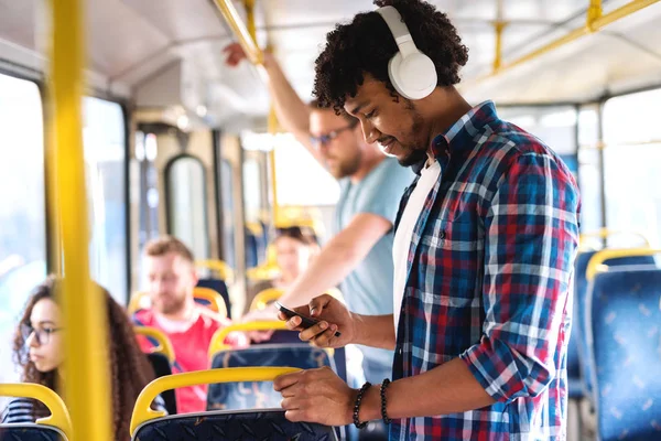 Joven Hombre Afroamericano Sonriente Escuchando Música Usando Teléfono Inteligente Mientras — Foto de Stock