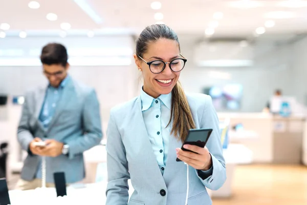 Mladá Běloška Oblečený Obleku Vyzkoušet Nový Chytrý Telefon Interiér Obchodu — Stock fotografie