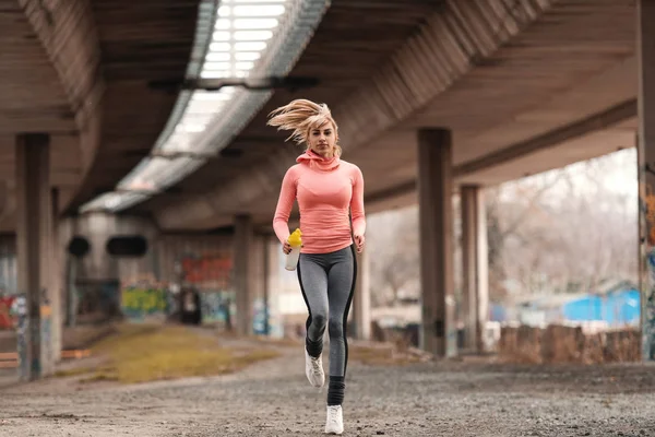 Hermosa Mujer Rubia Vestida Con Ropa Deportiva Corriendo Bajo Puente — Foto de Stock