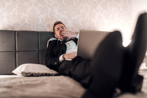 Young Tired Businessman Suit Yawning Using Laptop Work While Lying — 스톡 사진