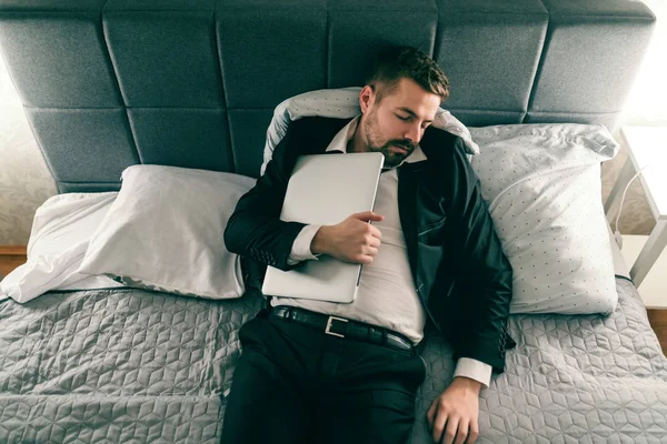 Hombre Negocios Sobrecargado Trabajo Traje Durmiendo Acostado Cama Sosteniendo Portátil — Foto de Stock