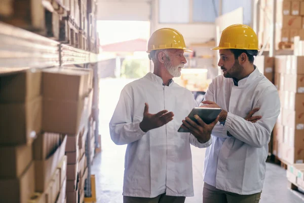 Dos Compañeros Trabajo Uniformes Blancos Con Cascos Amarillos Cabezas Discutiendo — Foto de Stock