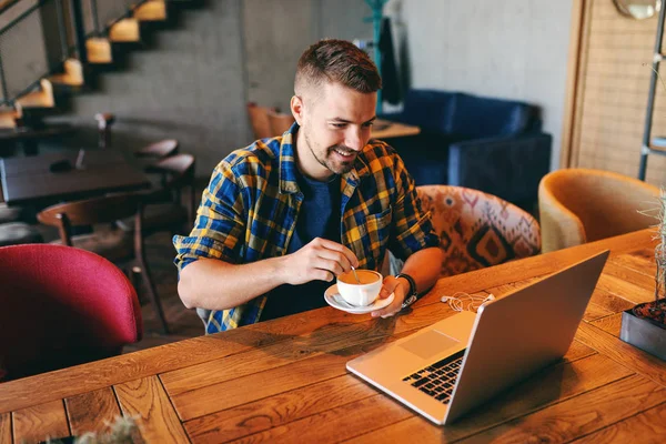 Freelancer Con Sonrisa Cara Bebiendo Café Mirando Portátil Mientras Está — Foto de Stock