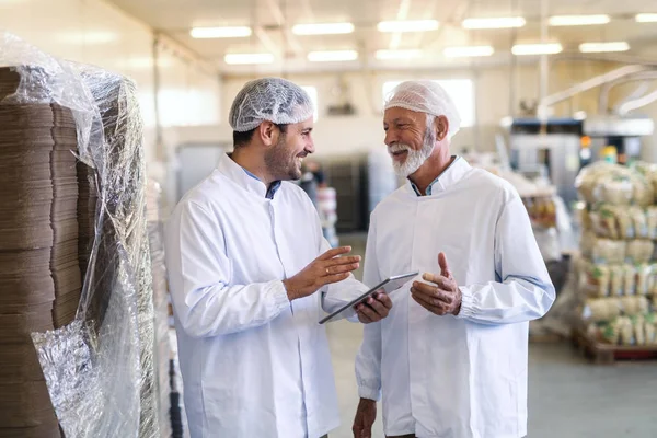 Vorgesetzter Spricht Mit Arbeiter Während Tablette Hält Beide Trugen Uniformen — Stockfoto