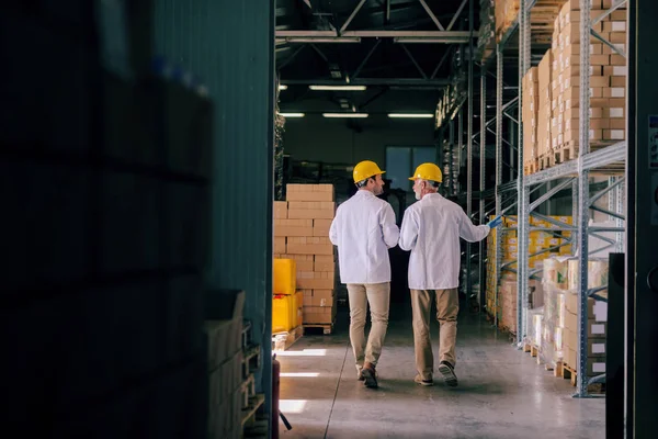 Two Storage Workers Uniforms Helmets Heads Walking Storage Talking Backs — 图库照片