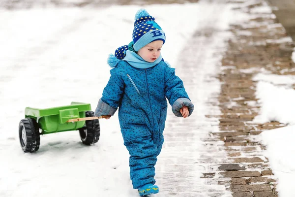 Lindo Niño Vestido Con Ropa Azul Invierno Arrastrando Juguete Del —  Fotos de Stock