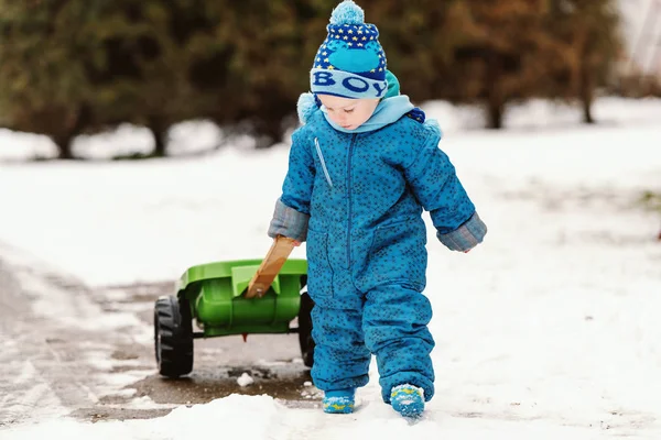 Lindo Niño Vestido Con Ropa Azul Invierno Arrastrando Juguete Del —  Fotos de Stock