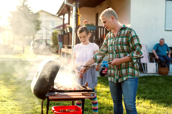 Vrouw Grillen Terwijl Schattig Klein Meisje Helpen Haar Een Achtertuin — Stockfoto