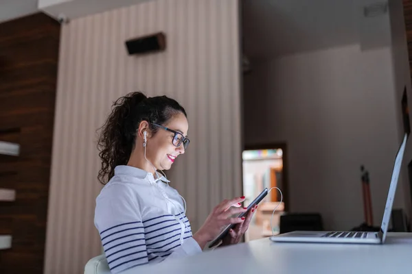 ハードの側面図の白人女性建築家のオフィスに坐っている間ビデオ通話のタブレットを使用して作業 デスク ノート パソコンの前に 白の色を支配 — ストック写真