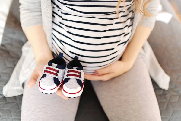 Kobieta Ciąży Kaukaska Trzyma Buty Dziecięce Dotykając Brzuch Bliska — Zdjęcie stockowe