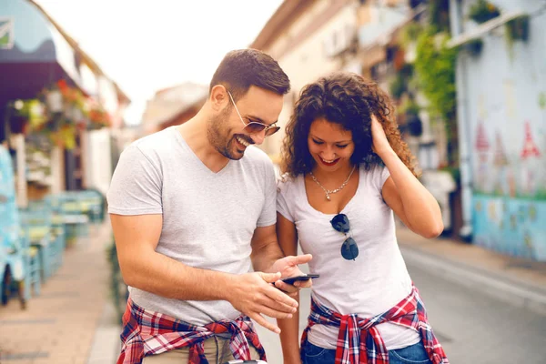 Χαμογελώντας Καυκάσιος Ζευγάρι Ανάγνωση Μηνύματος Στο Smart Phone Ενώ Πόδια — Φωτογραφία Αρχείου