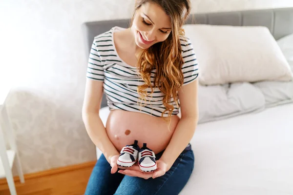 Πορτρέτο Του Έγκυος Χαμογελώντας Όμορφη Γυναίκα Κρατώντας Παπούτσια Μωρών Ενώ — Φωτογραφία Αρχείου