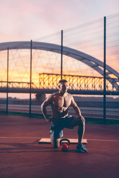 Shirtless Muscular Homem Ajoelhado Posando Quadra Pela Manhã — Fotografia de Stock