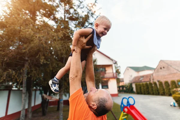 Abuelo Levantando Nieto Jugando Con Exterior Del Campo —  Fotos de Stock