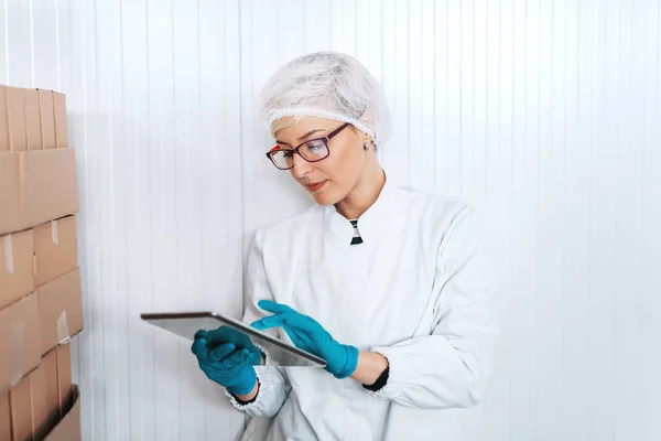 Empregada Loira Uniforme Estéril Usando Tablet Para Logística Enquanto Está — Fotografia de Stock