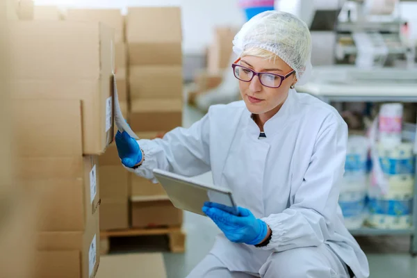 Caucasian Blonde Employee Sterile Uniform Crouching Next Boxes Dealing Logistic — Stock Photo, Image