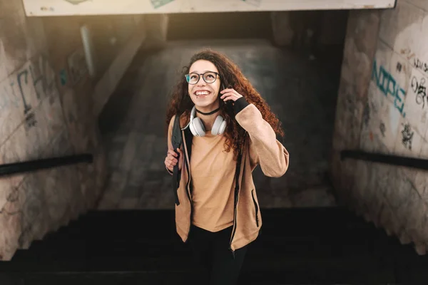 Tren Istasyonunda Merdiven Çıkma Uzun Kıvırcık Saçlı Genç Kız Gülümsüyor — Stok fotoğraf