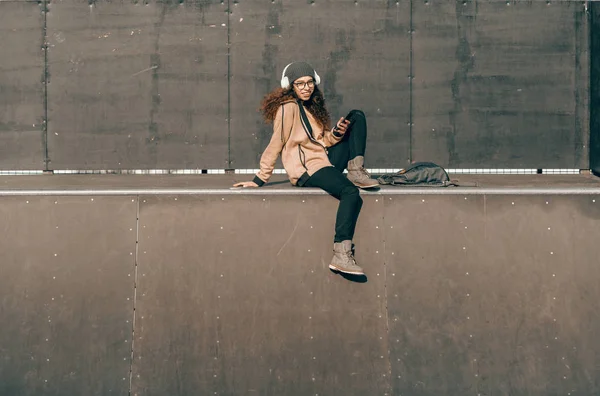 스케이트 공원에 앉아있는 스마트 전화를 머리와 Hipster — 스톡 사진