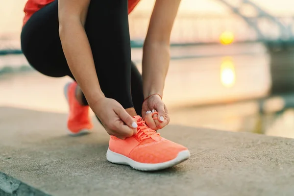 Wanita Sporty Mengikat Tali Sepatu Sambil Berlutut Luar Jembatan Latar — Stok Foto