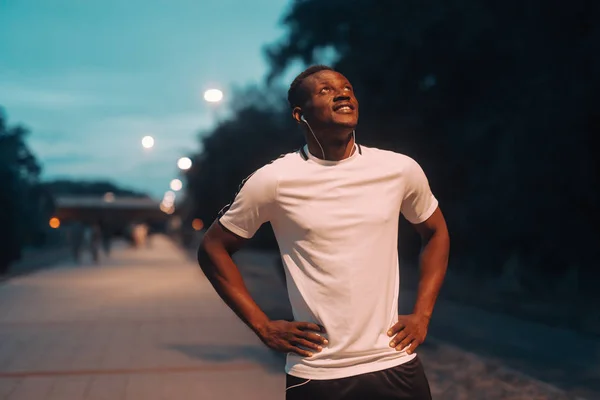 Smilende Flot Afrikaner Sportstøj Holder Hænder Hofter Ser Night Workout - Stock-foto