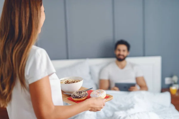 Atractiva Morena Llevando Desayuno Amado Esposo Hombre Sentado Cama Usando — Foto de Stock