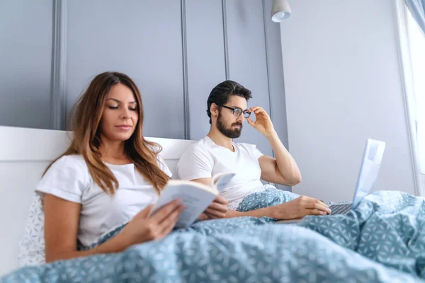 Schöne Kaukasische Brünette Buch Lesen Bett Während Ihr Mann Mit — Stockfoto