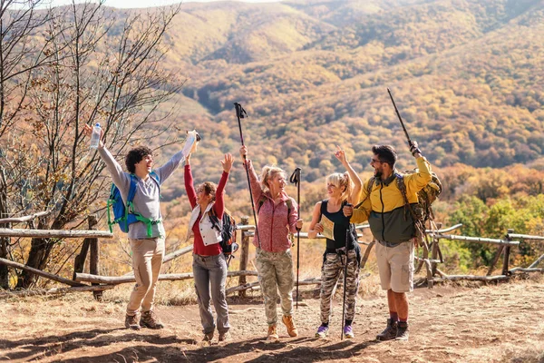 Grupo Caminhantes Felizes Com Mãos Para Cima Posando Clareira Montanhas — Fotografia de Stock