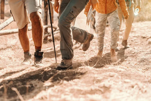 Close up of hikers\' feet climbing. Hiking in nature at autumn concept.