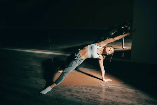 Jovem Morena Branca Esportiva Fazendo Ioga Alongamento Estúdio Fitness Escuro — Fotografia de Stock