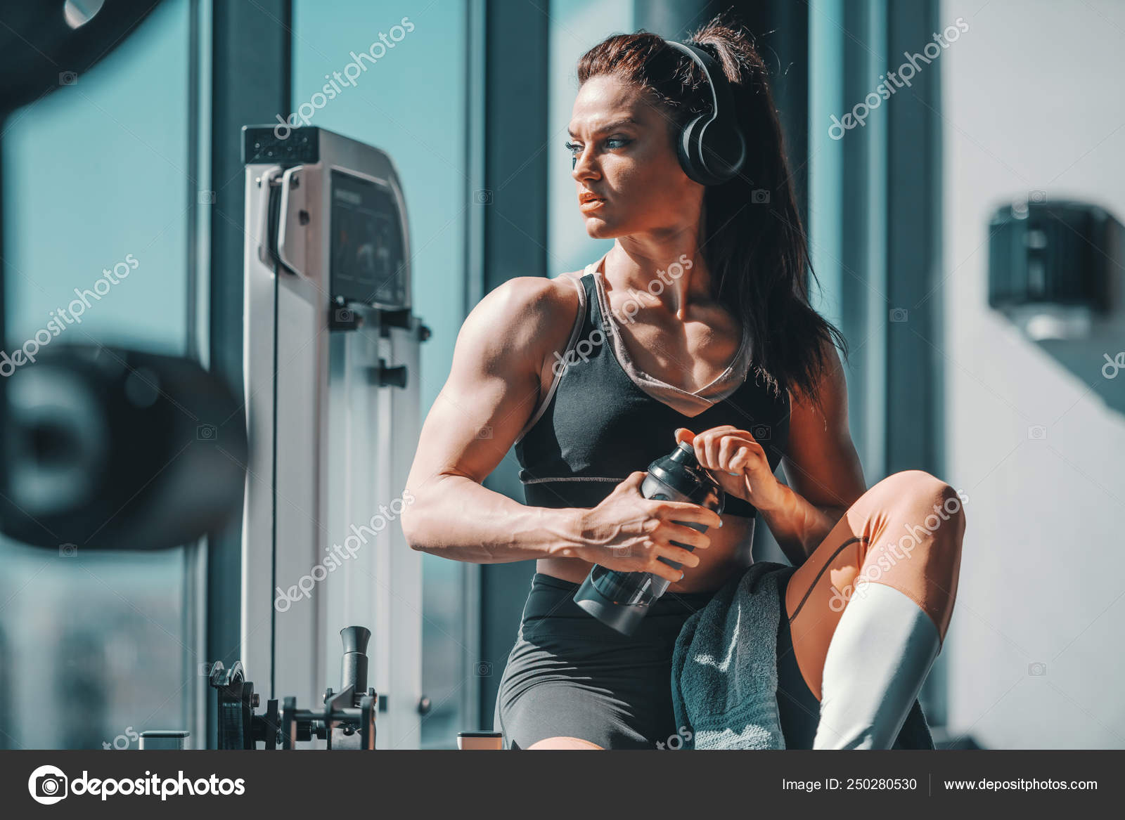 Female Bodybuilder Sitting Gym Headphones Ears Water Hands Stock Photo by  ©dusanpetkovic 250280530