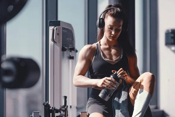 Young Caucasian Strong Muscular Female Bodybuilder Sitting Gym Headphones Ears — 스톡 사진