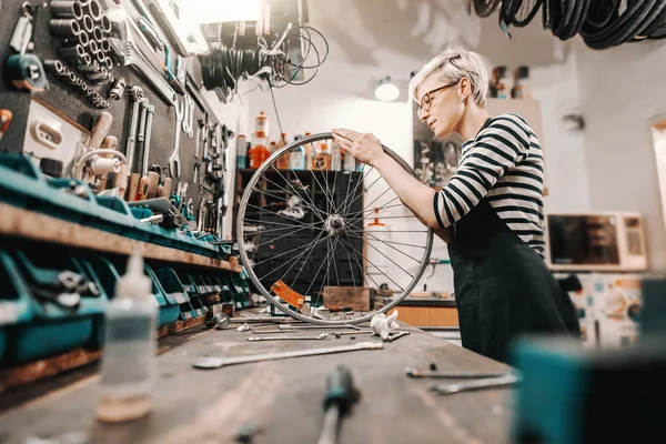 Schattig Kaukasische Vrouwelijke Werknemer Houden Fietswiel Terwijl Fiets Werkplaats Repareren — Stockfoto