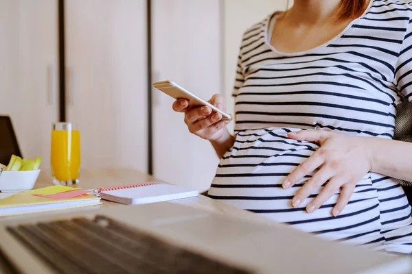 Молодая Беременная Женщина Использует Смартфон Сидя Столом Столе Ноутбук Здоровый — стоковое фото