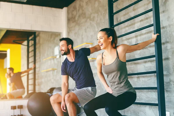 Couple Sportif Souriant Étirant Les Bras Position Accroupie Gym Intérieur — Photo