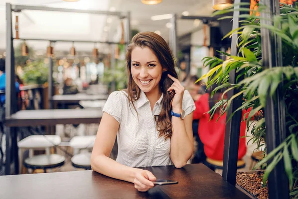 Sonriente Caucásico Atractivo Morena Vestida Elegante Sentado Cafetería Sosteniendo Teléfono — Foto de Stock