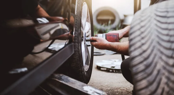 정비소에서 타이어를 바꾸는 자동차 정비사 선택적 — 스톡 사진