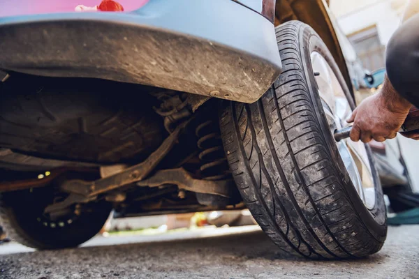 Mecánico Automático Que Utiliza Herramienta Para Cambiar Neumático Mientras Agacha —  Fotos de Stock